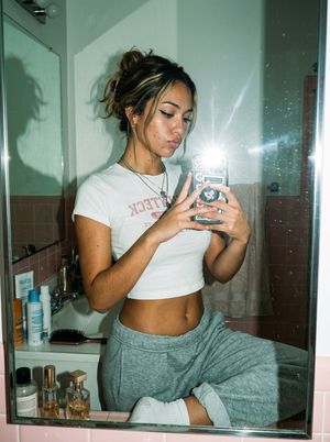 A realistic fashion-lifestyle mirror selfie prompt for generating candid...