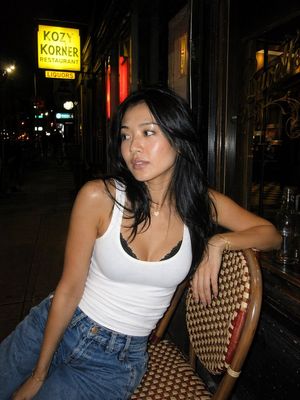 This prompt generates a realistic flash-lit urban nightlife portrait of...