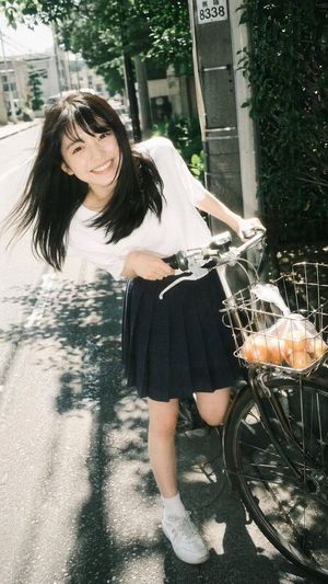 Generates a photorealistic, nostalgic portrait of a young woman posing w...